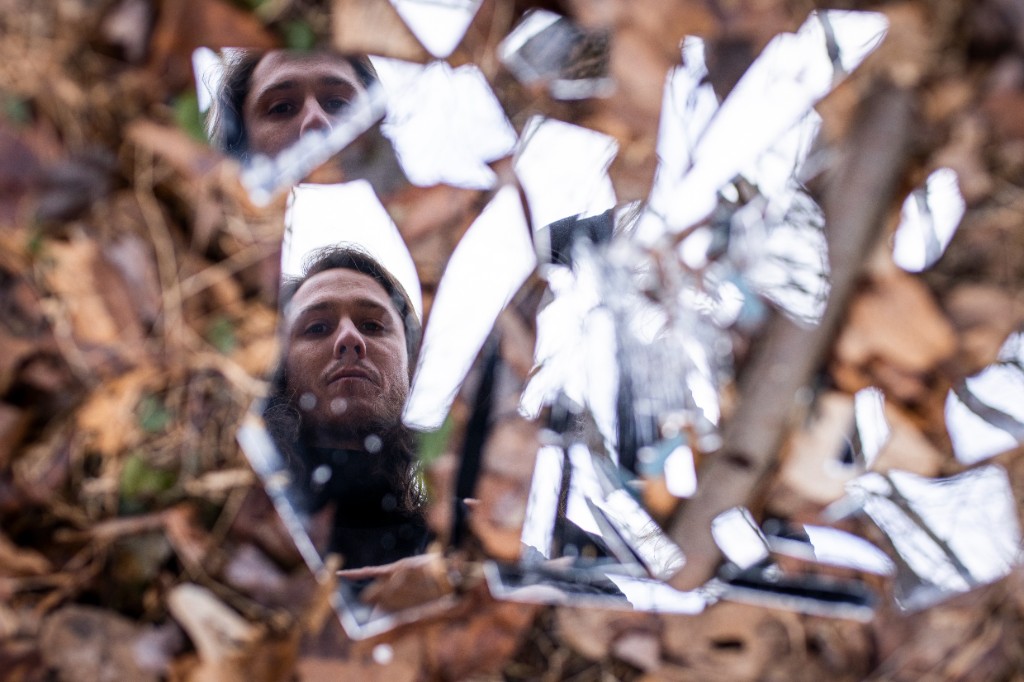 Group portrait of IMY2 band within ornate mirror frame in forest