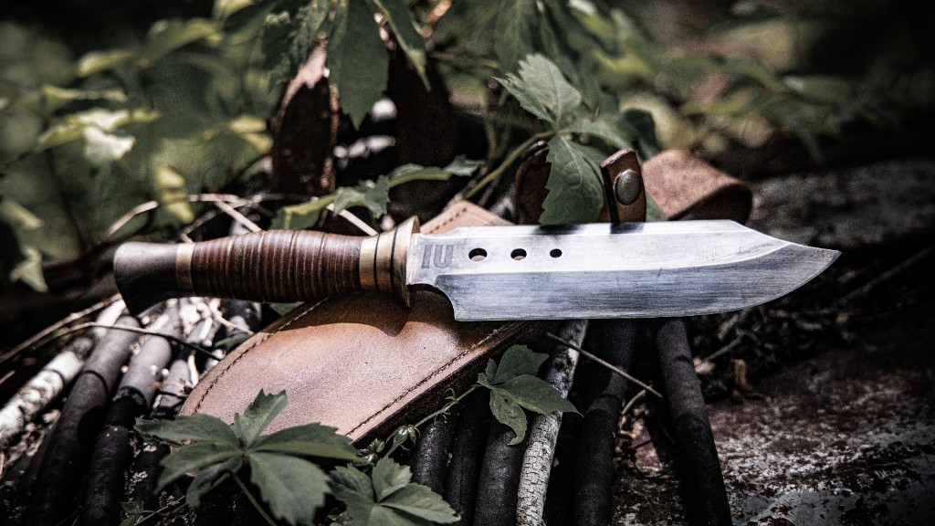 Knife with leather sheath on forest floor
