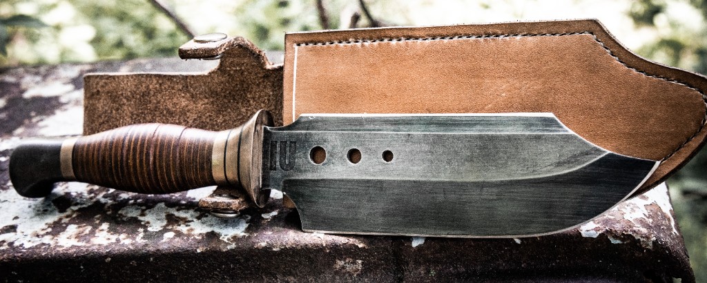 Knife and tan leather sheath on rusted industrial metal