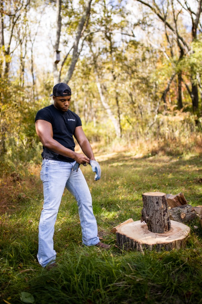 Tony Evans Jr. in woods pulling on work gloves