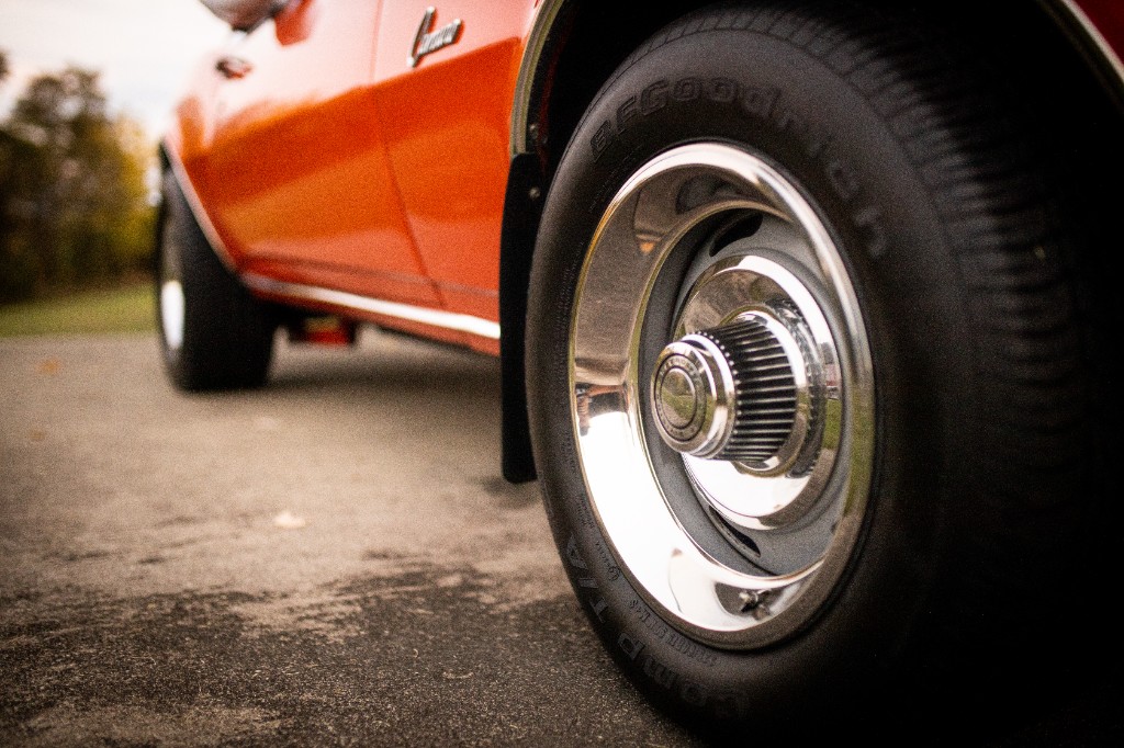 Chrome wheel with BFGoodrich tire and Camaro script on orange fender